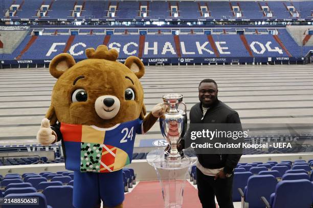 Gerlad Asamoah, ambassador of Gelsenkirchen poses with the official EURO 2024 trophy and Albärt, offical UEFA EURO 2024 mascot at the Arena during...