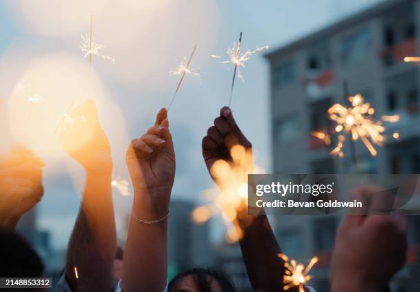 mani, stelle filanti e celebrazione di amici in città a festa all'aperto in città insieme a fuoco, luce o fiamma. fuochi d'artificio, bagliore e gruppo di persone primo piano in vacanza o in vacanza con petardo - candela magica foto e immagini stock