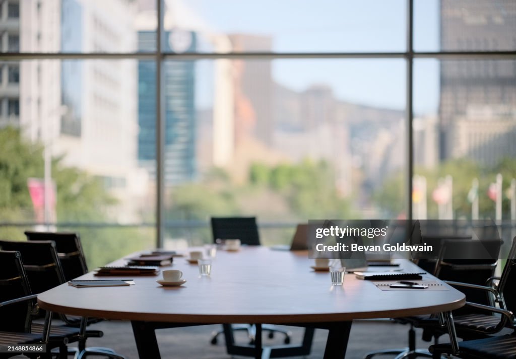 Chairs, table and technology in empty boardroom of corporate office for meeting with window view. Furniture, interior and still life desk with nobody in company workplace for professional career