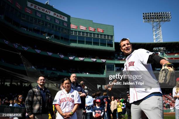 Rob Gronkowski, former NFL player for the New England Patriots warms up his arm with a ball attendant before throwing out the ceremonial first pitch...