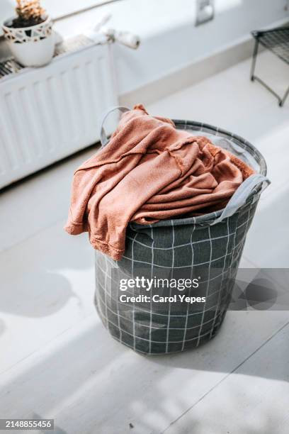 laundry basket at home. filled with clothes - wasmand stockfoto's en -beelden