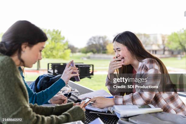 teenager-mädchen benutzen telefone, anstatt hausaufgaben zu machen - druck durch gleichaltrige stock-fotos und bilder