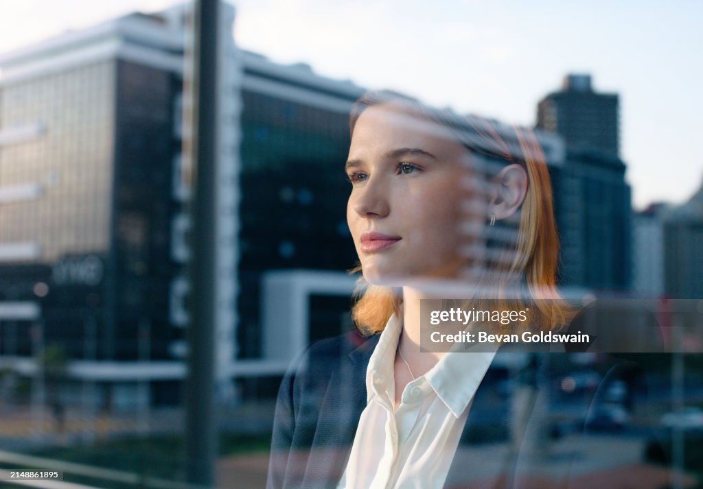 Business woman, window and thinking for urban development, inspiration for architecture and infrastructure. Reflection, innovation and insight with property, ideas and future of profession for growth