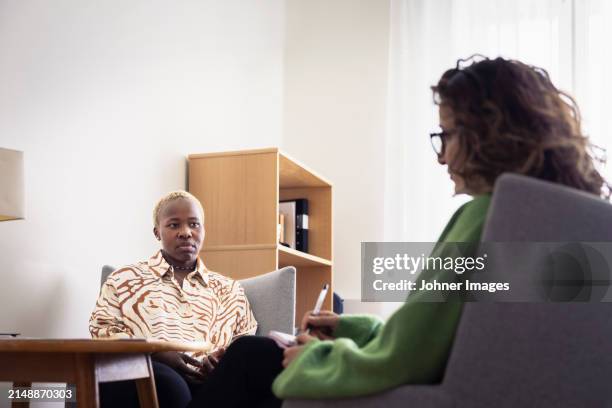 mid adult woman sitting during therapy session - body conscious stock pictures, royalty-free photos & images