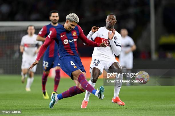Nuno Mendes of Paris Saint-Germain is challenged by Ronald Araujo of FC Barcelona during the UEFA Champions League quarter-final second leg match...