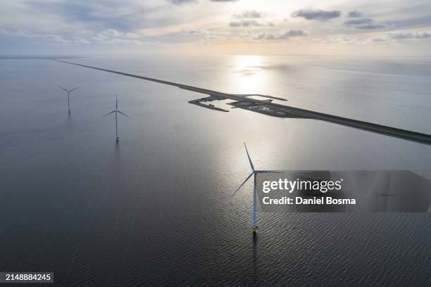 the afsluitdijk and wind turbines seen from the air during sunset - afsluitdijk stockfoto's en -beelden