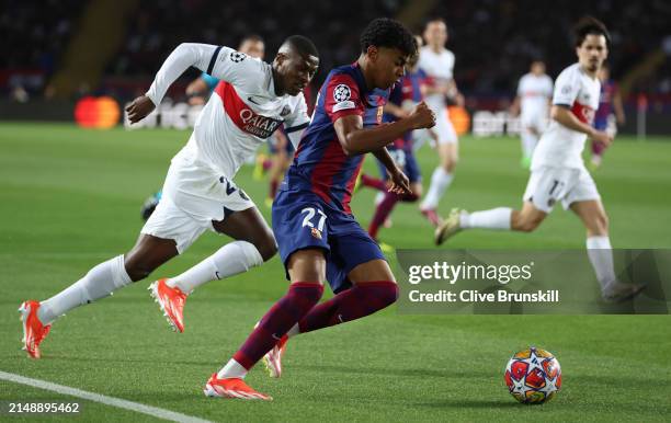 Lamine Yamal of FC Barcelona moves away from Nuno Mendes of Paris Saint-Germain during the UEFA Champions League quarter-final second leg match...