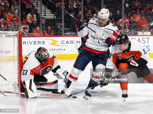 Samuel Ersson and Bobby Brink of the Philadelphia Flyers defend against Nicolas Aube-Kubel of the Washington Capitals during the first period at the...