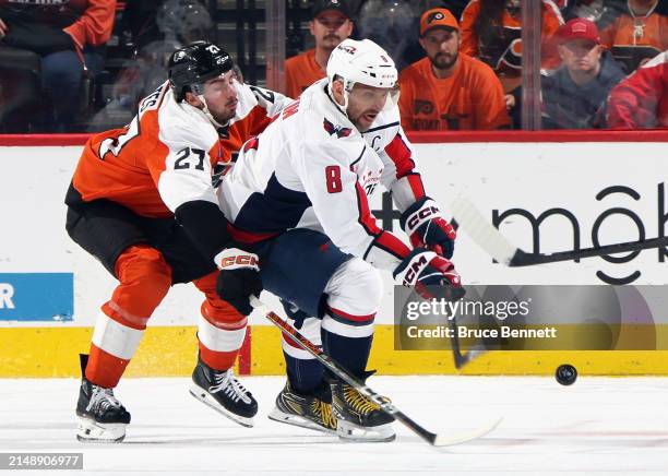 Noah Cates of the Philadelphia Flyers checks Alex Ovechkin of the Washington Capitals during the third period at the Wells Fargo Center on April 16,...