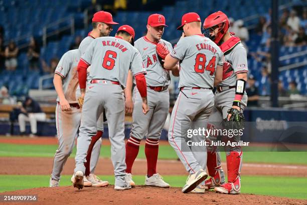 Pitching coach Barry Enright of the Los Angeles Angels meets with Carson Fulmer on the mound in the 13th inning against the Tampa Bay Rays at...