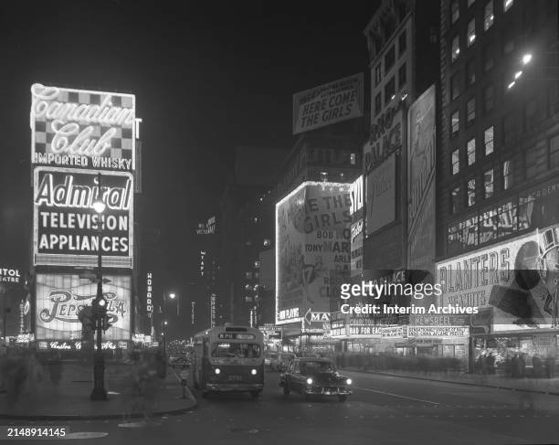 Nighttime view looking north at vehicular traffic and the neon advertising signs in Times Square, New York City, New York, December 29, 1953. Visible...