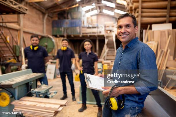 geschäftsführer lächelt in einer holzfabrik - holzlager stock-fotos und bilder