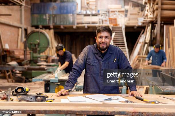 man working at a wood factory and looking at the camera smiling - snickare bildbanksfoton och bilder