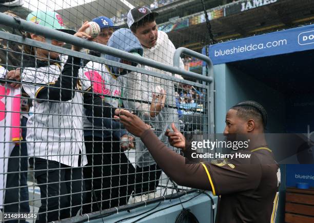 Jurickson Profar of the San Diego Padres signs autographs before the game against the Los Angeles Dodgers at Dodger Stadium on April 14, 2024 in Los...