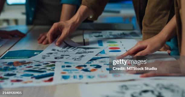 close-up of team hands analyzing environmental social governance (esg) reports, reinforcing responsible business strategies in an office setting. esg sustainable business office night. - obscured face stock pictures, royalty-free photos & images