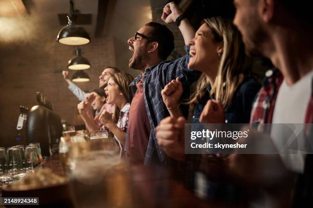watching successful sports match in a pub! - sports bar stock pictures, royalty-free photos & images