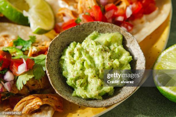 avocado guacamole sauce in bowl with tacos - sour cream stock pictures, royalty-free photos & images