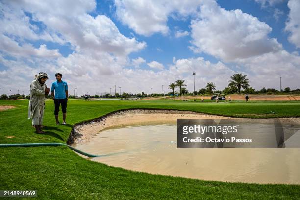 Grounds Staff drain water from the flooded bunker area on the course prior to the Abu Dhabi Challenge at Al Ain Equestrian, Shooting and Golf Club on...