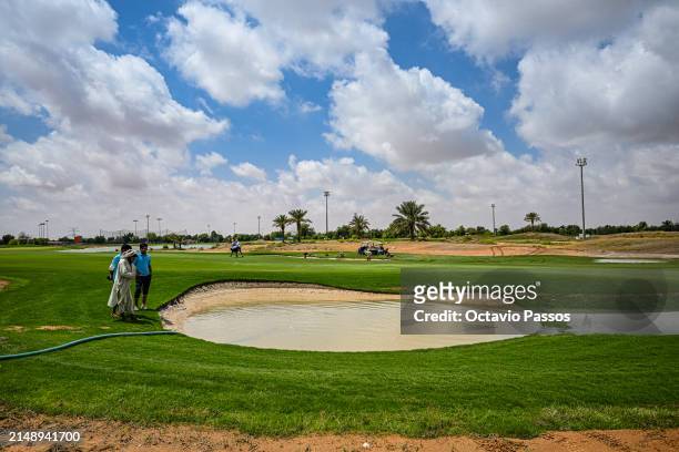 Grounds Staff drain water from the flooded bunker area on the course prior to the Abu Dhabi Challenge at Al Ain Equestrian, Shooting and Golf Club on...
