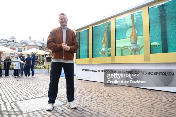 Greg Rutherford MBE poses for a photo as he attends the synchronized swimming event by On Location celebrating 100 days until the Paris 2024 Olympic...