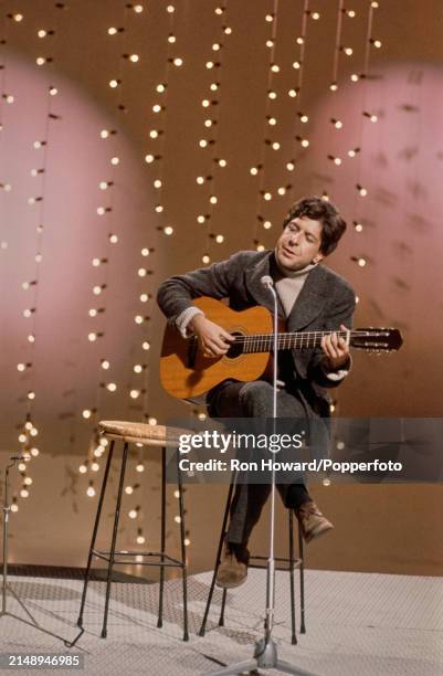 Canadian singer and songwriter Leonard Cohen performs on the set of a music television show in London circa 1968.