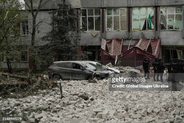Police members stand amid rubble in front of object of social infrastructure destroyed as result of missile attack on April 17, 2024 in Chernihiv,...