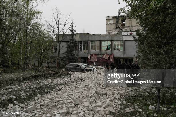 Police members stand amid rubble in front of object of social infrastructure destroyed as result of missile attack on April 17, 2024 in Chernihiv,...