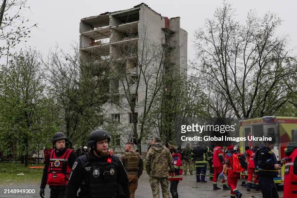 Police and military members stand in front of object of social infrastructure destroyed as result of missile attack on April 17, 2024 in Chernihiv,...