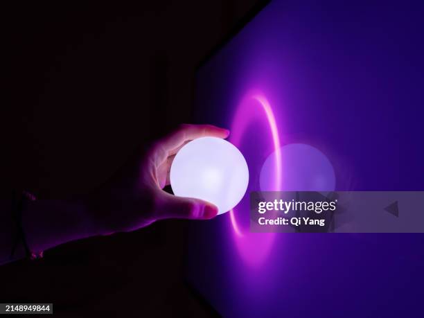 connect to the future, close-up of glowing ball touching computer screen - sanciones fotografías e imágenes de stock