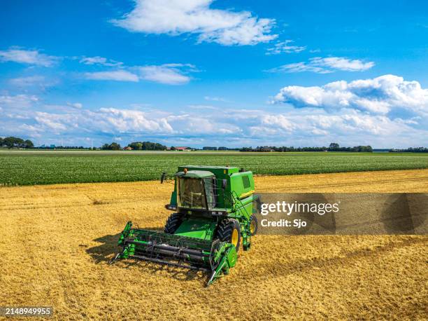 john deere mähdrescher bei der weizenernte im sommer von oben gesehen - landwirtschaftliche maschine stock-fotos und bilder