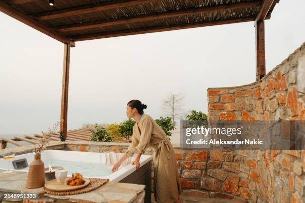 asian woman preparing a hot tub bath - woman in hot tub stock pictures, royalty-free photos & images