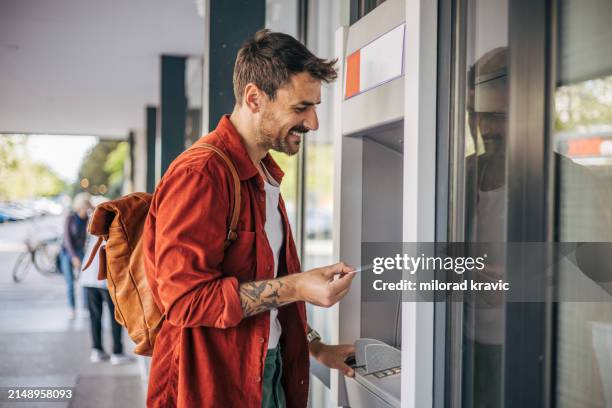 a man withdraws money from an atm. - pin entry stock pictures, royalty-free photos & images