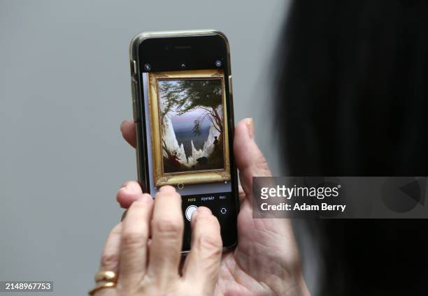 Visitor takes a photo of the painting "Kreidefelsen auf Rügen" or "Chalk Cliffs on Rügen" by Caspar David Friedrich at the press preview of the...