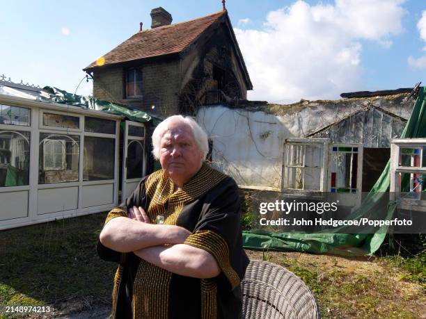 English film director and photographer Ken Russell stands outside his fire damaged cottage in the village of East Boldre in the New Forest area of...