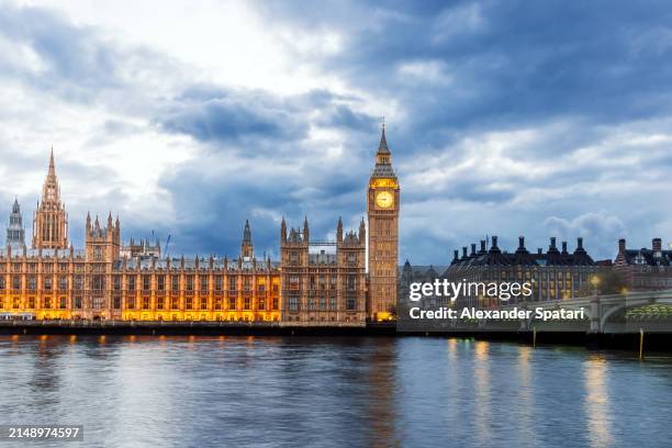 houses of parliament, big ben and westminster bridge illuminated at dusk, london, england, uk - palace of westminster stock-fotos und bilder