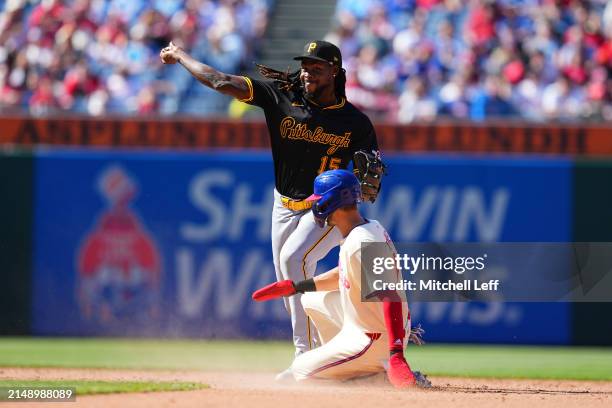 Oneil Cruz of the Pittsburgh Pirates attempts to turn a double play against Trea Turner of the Philadelphia Phillies at Citizens Bank Park on April...