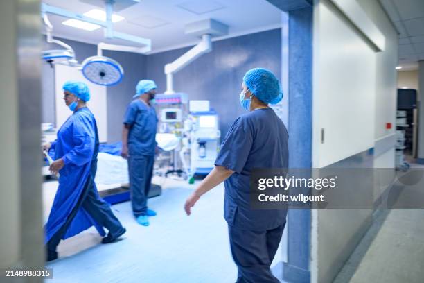motion medical staff in scrubs walking into surgery operating room - sala de cirurgia com assistência imagens e fotografias de stock