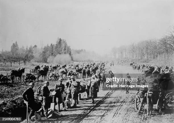 Americans going to front, Feb 1918. Photo shows American soldiers moving equipment along dirt road in Saint-Ouen-le`s-Parey, France, February 1918,...