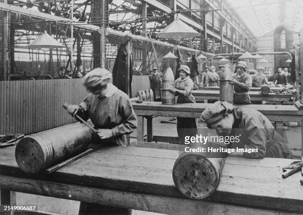 English women finishing a 9.2 shell, between circa 1915 and 1917. Women workers inspecting 9.2 explosive shells in a factory during World War I....