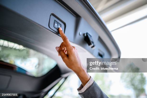 woman presses the button to close the trunk of the car - car trunk closed stock pictures, royalty-free photos & images