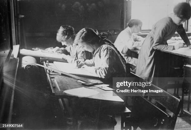 London Common Council Tech., Lessons in Tracing, May 1917. Women receiving training in machine work in a munitions class offered by the London County...