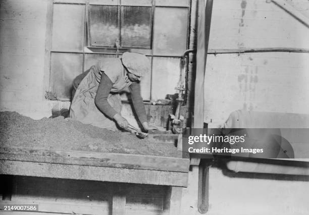 English women sifting steel grit, between circa 1915 and 1918. Woman working in factory in England during World War I. Creator: Bain News Service.