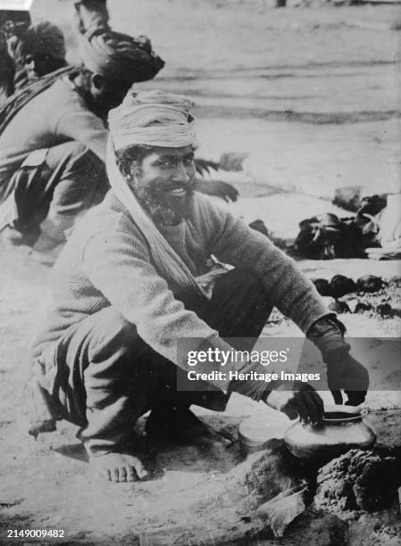 Indian soldier cooking, in France, between circa 1914 and circa 1915. An Indian soldier cooking outside over an open fire in France during World War...