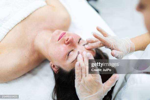 cosmetologist making face massage to patient - pimple stock pictures, royalty-free photos & images