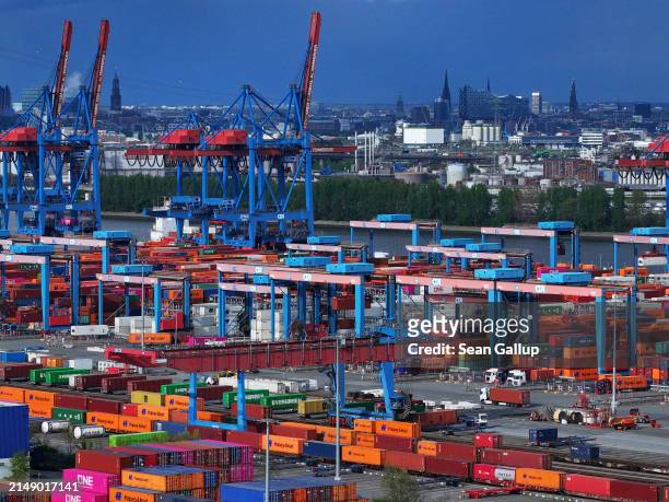 Shipping containers lie stacked at Hamburg Port as the Elbphilharmonie philharmonic hall stands behind on April 17, 2024 in Hamburg, Germany. The...