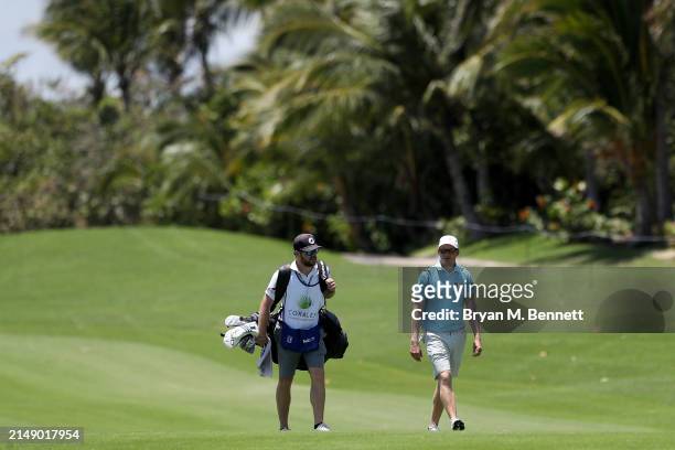 Adam Long of the United States and his caddie walk up the seventh fairway during a practice round prior to the Corales Puntacana Championship at...