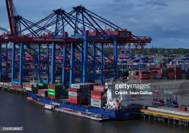 In this aerial view cranes unload shipping containers from a cargo ship at Hamburg Port on April 17, 2024 in Hamburg, Germany. The International...