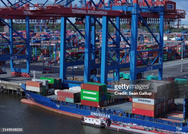 In this aerial view cranes unload shipping containers from a cargo ship at Hamburg Port on April 17, 2024 in Hamburg, Germany. The International...