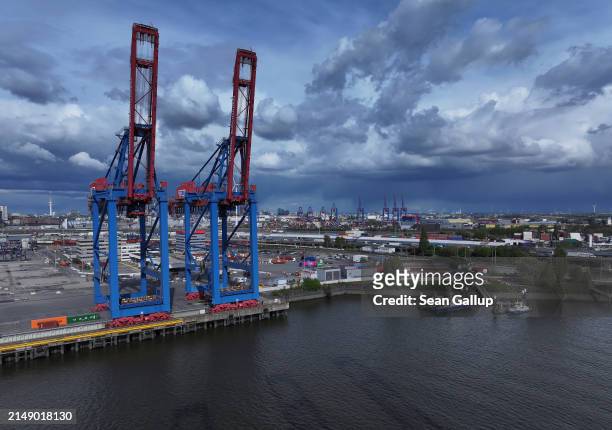 In this aerial view container cranes stand at Hamburg Port on April 17, 2024 in Hamburg, Germany. The International Monetary Fund has reduced its...