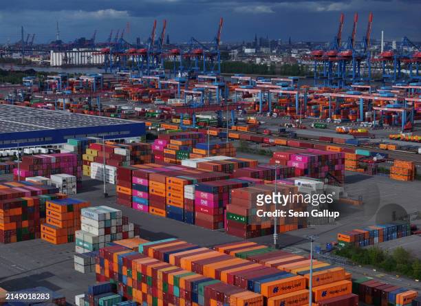 Shipping containers lie stacked at Hamburg Port on April 17, 2024 in Hamburg, Germany. The International Monetary Fund has reduced its prognosis for...